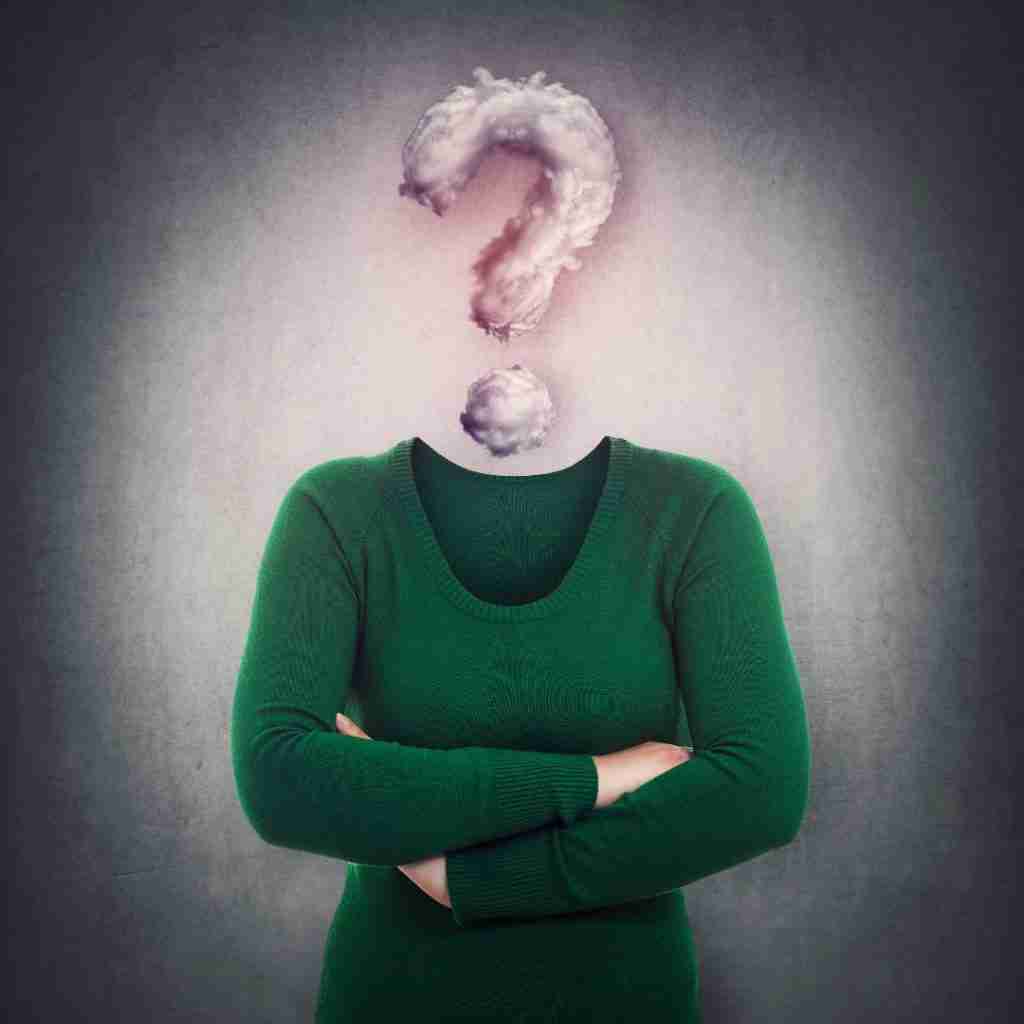 Holiday gifts for your favourite ADHD-brains 1 A person in a green sweater with arms crossed stands against a gray background, their head replaced by a cloud forming a question mark—evoking the curiosity and wonder behind choosing perfect ADHD holiday gifts.