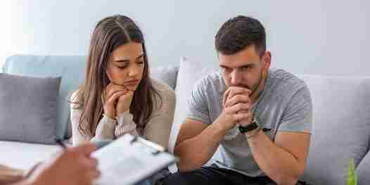 ADHD Couples: Solutions Beyond Traditional Therapy 5 A picture of a couple in therapy sitting on a gray couch