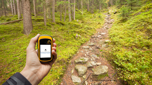 Image of a man on a hike holding out a compass