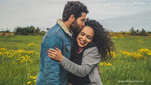 Image of a happy couple embracing in a field