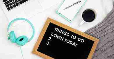 ADHD Essentials: 8 Therapist-Guided Tips for Thriving with Your ADHD Brain 9 A flat lay of a workspace featuring a laptop, mint green headphones, a notepad with a pen, and a cup of coffee. A chalkboard displays Things to Do: 1. Own Today 2. 3. alongside an ADHD Essentials guide on the white surface.