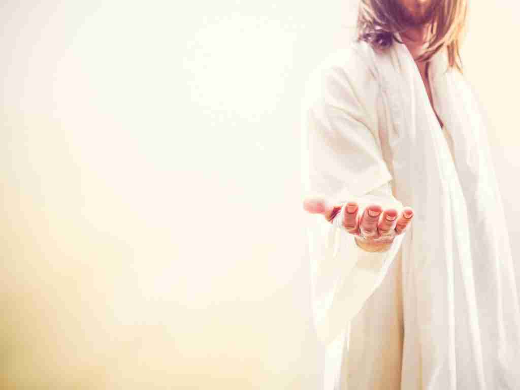 A person dressed in a light, flowing robe extends an open hand outward. The background is softly lit, creating a warm and inviting atmosphere that echoes ADHD acceptance. The focus is on the hand, symbolizing an offering or gesture of welcome to ADHD families.